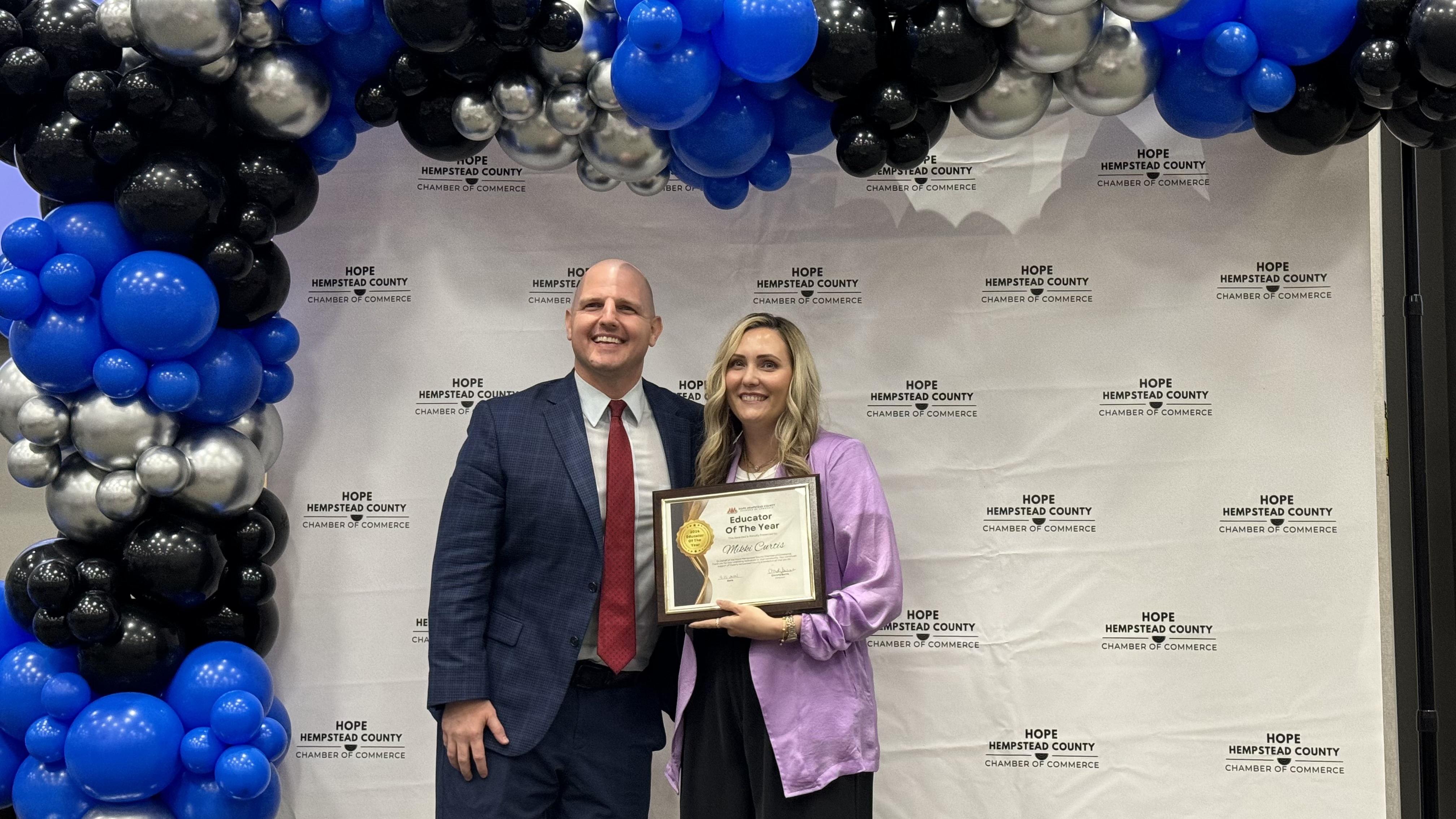 Hope Public Schools Superintendent Dr. Jonathan Crossley presents Dr. Mikki Curtis with the 2024 Hempstead County Educator of the Year Award